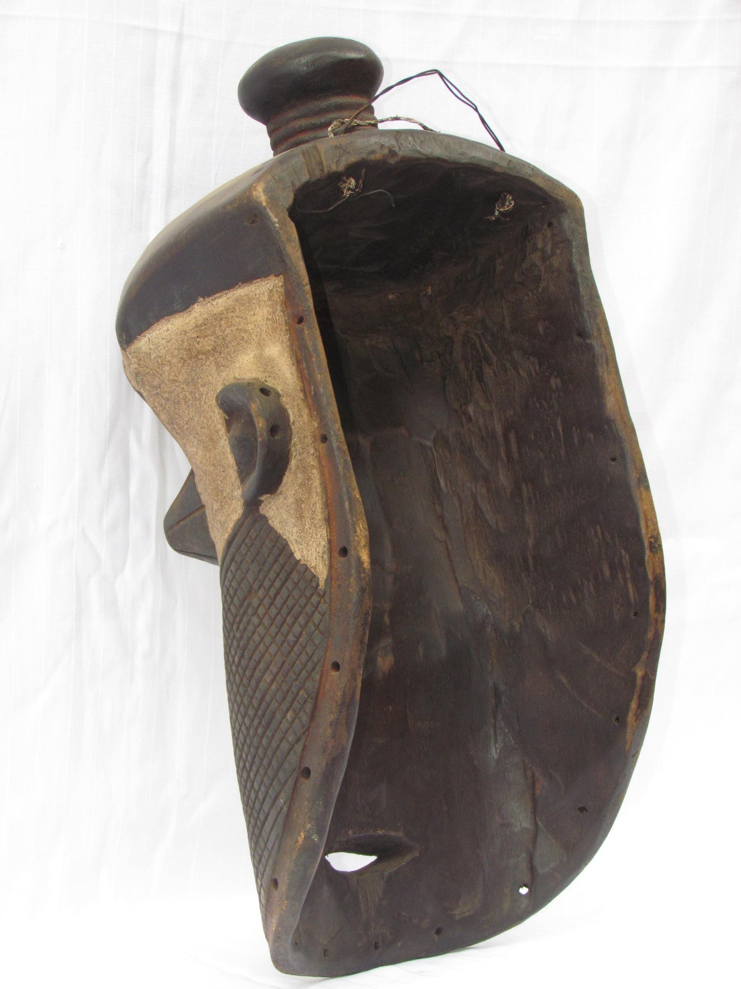Un masque mural traditionnel africain en bois sculpté à la main de couleur marron, de la RDC