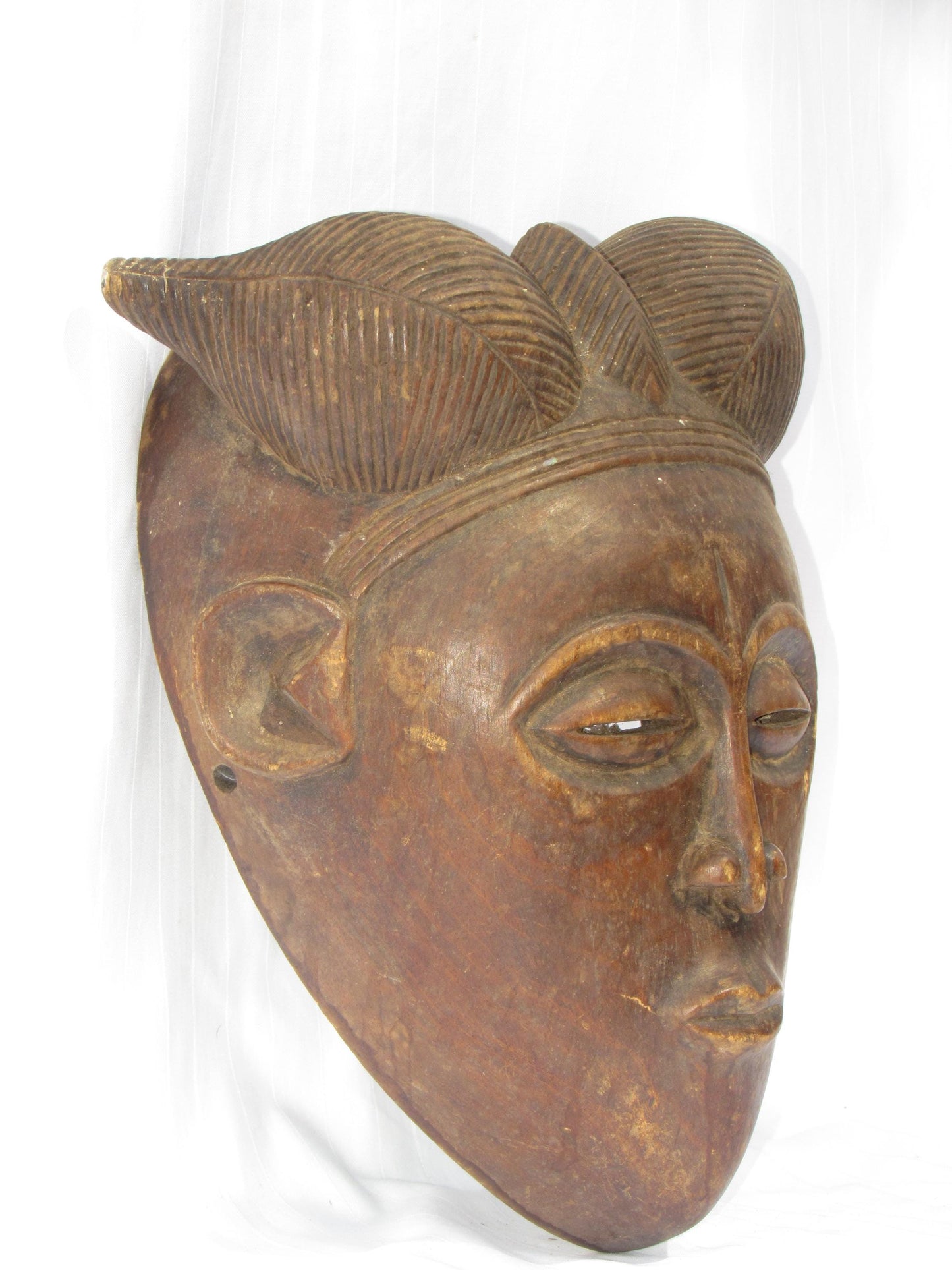 Une tenture murale vintage marron sculptée à la main, masques traditionnels africains en bois de RDC