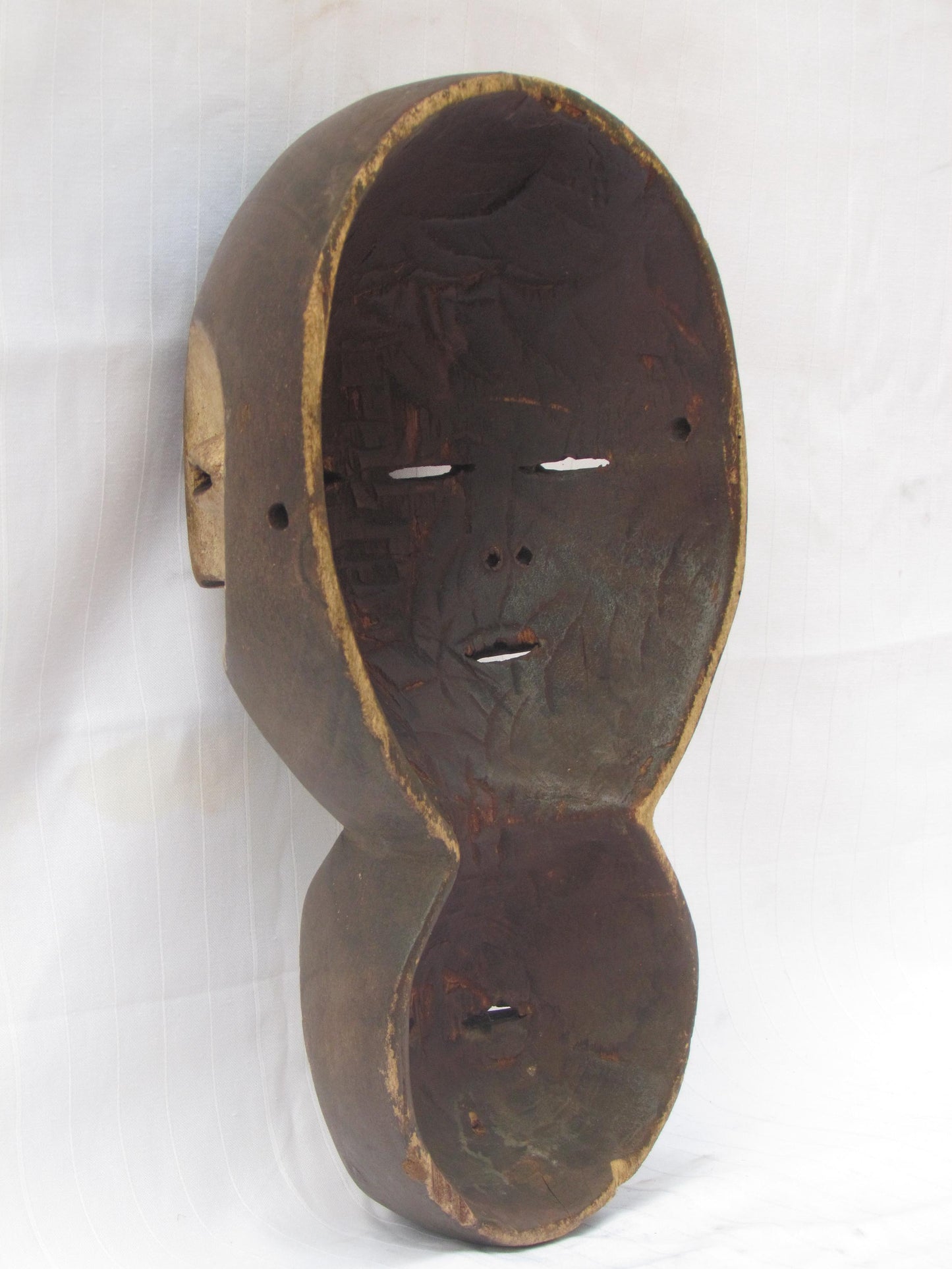 Un masque mural traditionnel africain en bois sculpté à la main à plusieurs visages de la RDC