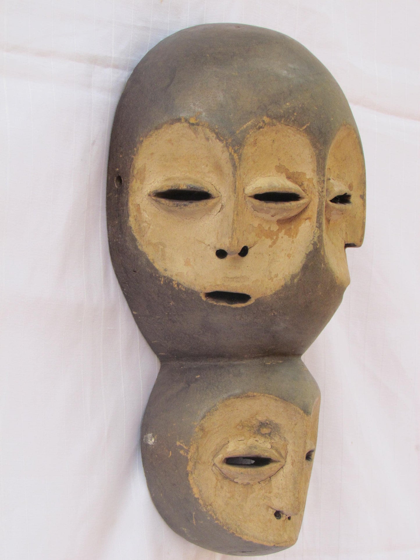 Un masque mural traditionnel africain en bois sculpté à la main à plusieurs visages de la RDC
