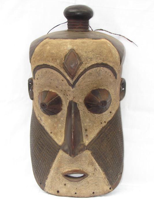 Un masque mural traditionnel africain en bois sculpté à la main de couleur marron, de la RDC