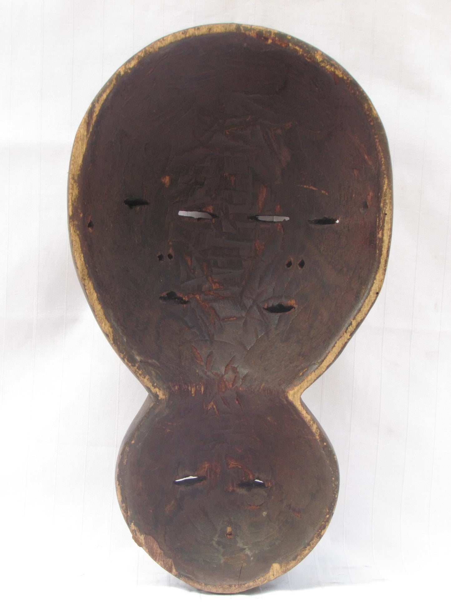 Un masque mural traditionnel africain en bois sculpté à la main à plusieurs visages de la RDC