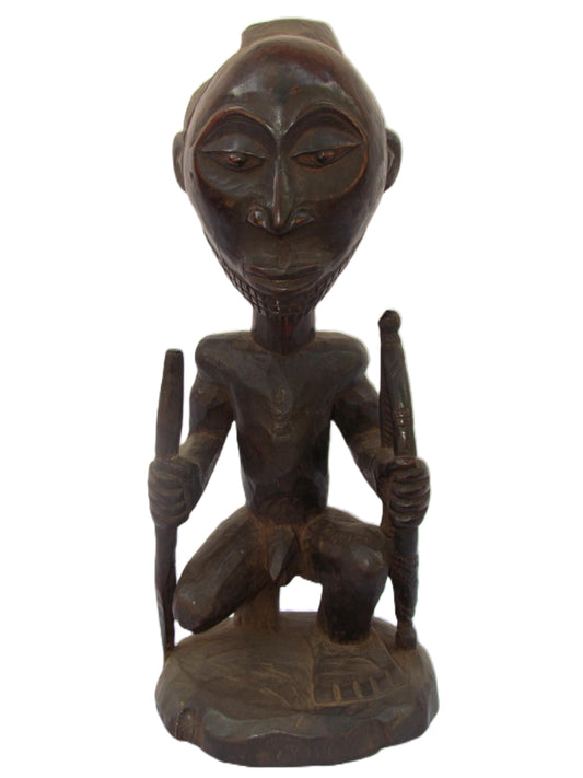 Une statue de sécurité Luba africaine masculine guidée avec des bâtons de combat dans les deux bras du Congo