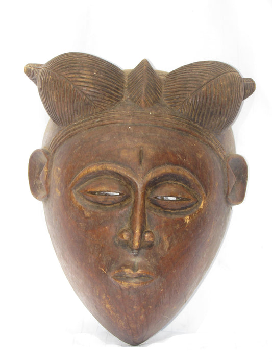 Une tenture murale vintage marron sculptée à la main, masques traditionnels africains en bois de RDC